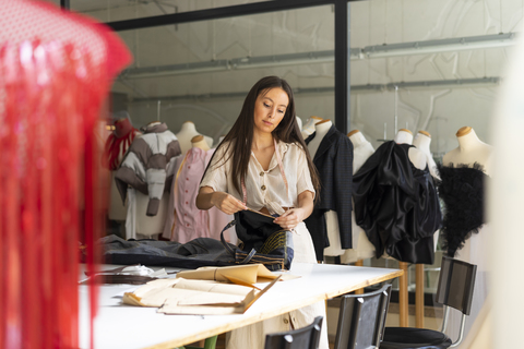 Young fashion designer working in her studio